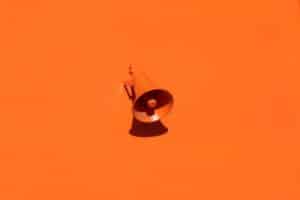 Megaphone auf orangenem Hintergrund als Sinnbild für Reichweite - [https://unsplash.com/photos/QRKJwE6yfJo]