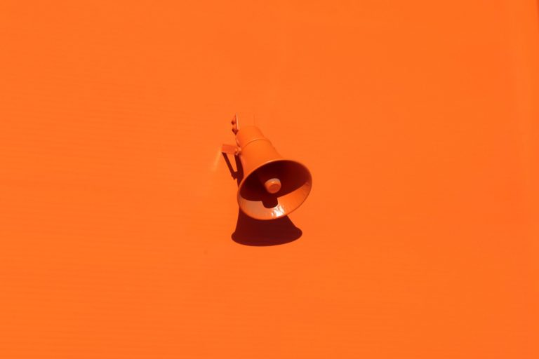 Megaphone auf orangenem Hintergrund als Sinnbild für Reichweite - [https://unsplash.com/photos/QRKJwE6yfJo]